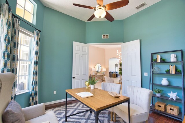 8209 Snowy Egret Pl, Bradenton, FL 34202 - home office featuring arched walkways, dark wood-style floors, ceiling fan, a high ceiling, and baseboards