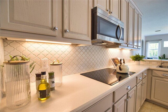 8209 Snowy Egret Pl, Bradenton, FL 34202 - kitchen with stainless steel microwave, black electric stovetop, a sink, and light countertops