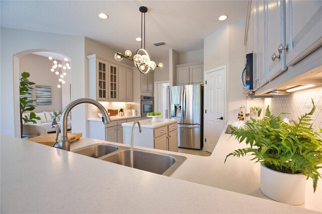 8209 Snowy Egret Pl, Bradenton, FL 34202 - kitchen with appliances with stainless steel finishes, light countertops, glass insert cabinets, pendant lighting, and recessed lighting