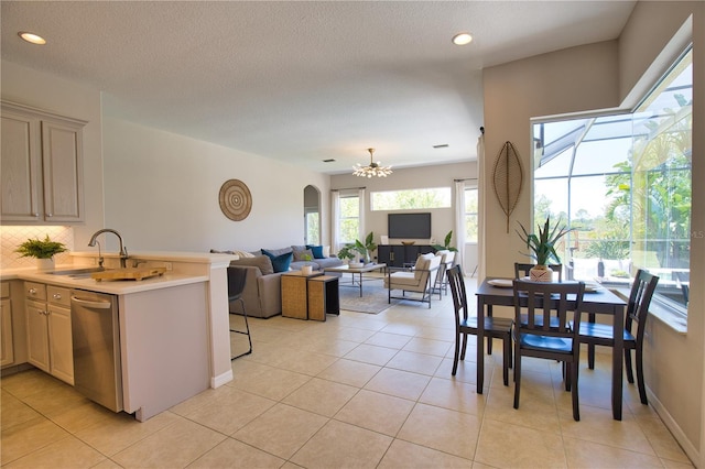 8209 Snowy Egret Pl, Bradenton, FL 34202 - kitchen with dishwasher, a sink, light countertops, a chandelier, and light tile patterned flooring