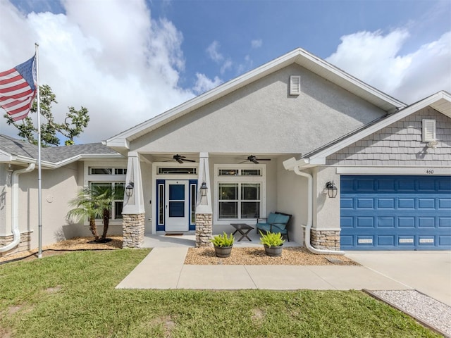 460 Bard Rd, Venice, FL 34293 - view of front of property featuring stucco siding, stone siding, a ceiling fan, a front yard, and an attached garage