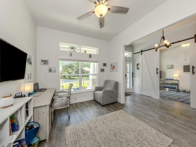 460 Bard Rd, Venice, FL 34293 - office with a barn door, wood finished floors, a ceiling fan, and baseboards