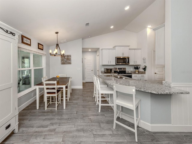 460 Bard Rd, Venice, FL 34293 - kitchen with appliances with stainless steel finishes, a chandelier, a breakfast bar, a sink, and lofted ceiling