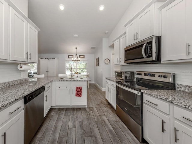 460 Bard Rd, Venice, FL 34293 - kitchen with appliances with stainless steel finishes, a sink, a chandelier, a peninsula, and white cabinets