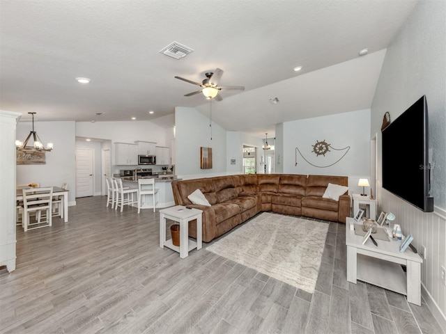 460 Bard Rd, Venice, FL 34293 - living room with vaulted ceiling, a chandelier, a ceiling fan, and light wood-type flooring