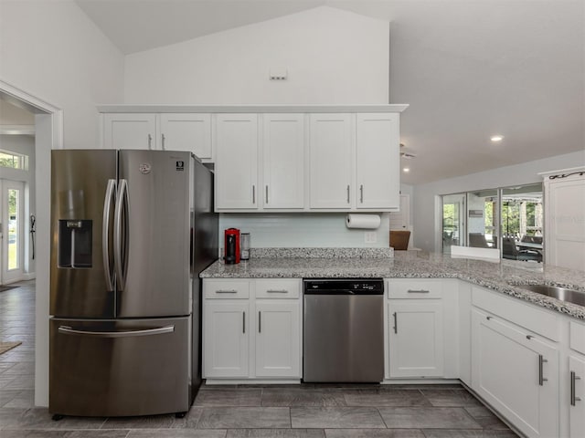 460 Bard Rd, Venice, FL 34293 - kitchen with stainless steel appliances, white cabinets, plenty of natural light, lofted ceiling, and light stone countertops