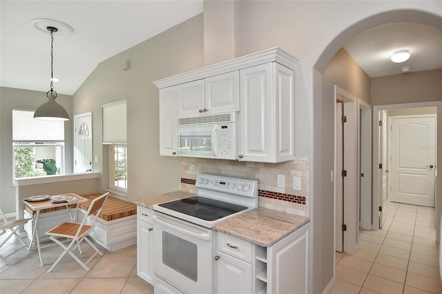 1104 Auburn Cove Cir, Venice, FL 34292 - kitchen featuring white appliances, light tile patterned flooring, arched walkways, tasteful backsplash, and white cabinetry
