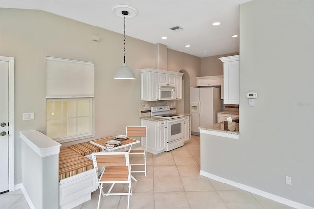 1104 Auburn Cove Cir, Venice, FL 34292 - kitchen with white appliances, white cabinetry, light tile patterned flooring, decorative light fixtures, and arched walkways