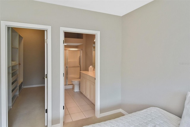 1104 Auburn Cove Cir, Venice, FL 34292 - bedroom with baseboards, light tile patterned floors, and connected bathroom