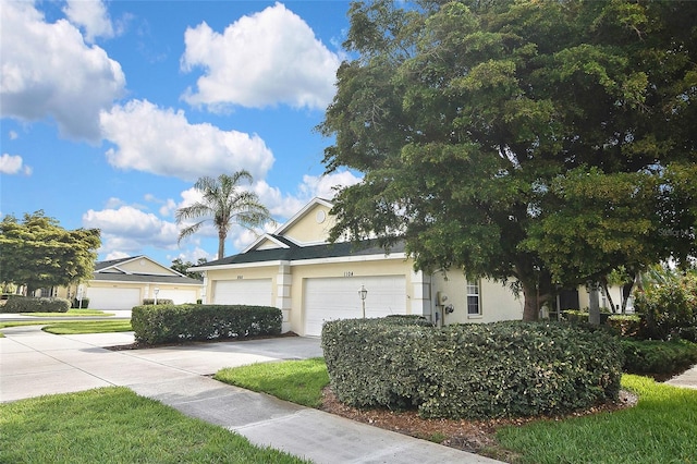 1104 Auburn Cove Cir, Venice, FL 34292 - view of property hidden behind natural elements featuring stucco siding, an attached garage, and concrete driveway