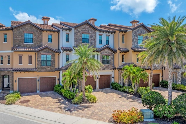 209 E Venice Ave, Venice, FL 34285 - view of front of property featuring a garage, stucco siding, stone siding, and a tiled roof