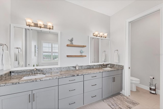 209 E Venice Ave, Venice, FL 34285 - bathroom featuring double vanity, toilet, and baseboards