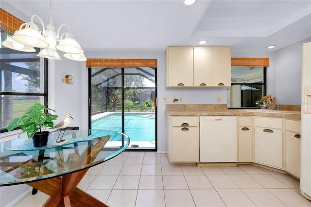 915 S Doral Ln, Venice, FL 34293 - kitchen with white dishwasher, a raised ceiling, light countertops, decorative light fixtures, and recessed lighting