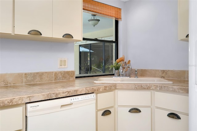 915 S Doral Ln, Venice, FL 34293 - kitchen with dishwasher, a sink, tile countertops, and white cabinetry