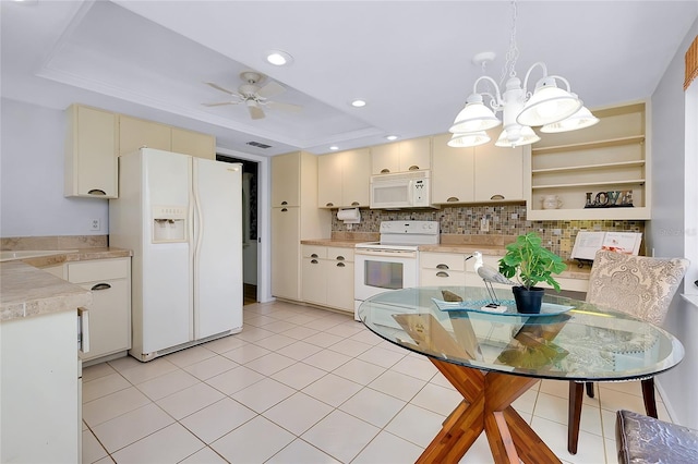 915 S Doral Ln, Venice, FL 34293 - kitchen with white appliances, a tray ceiling, light countertops, a chandelier, and cream cabinetry