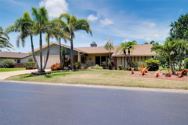 915 S Doral Ln, Venice, FL 34293 - view of front facade featuring a front lawn, an attached garage, concrete driveway, and a chimney