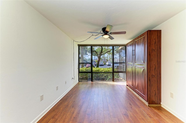 618 Bird Bay Dr S Unit 110, Venice, FL 34285 - spare room with wood finished floors, a ceiling fan, and baseboards