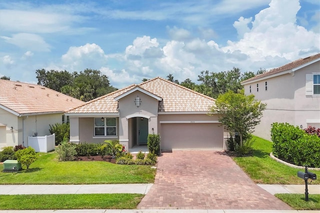 2034 Mesic Hammock Way, Venice, FL 34292 - mediterranean / spanish home with a tile roof, an attached garage, decorative driveway, stucco siding, and a front yard