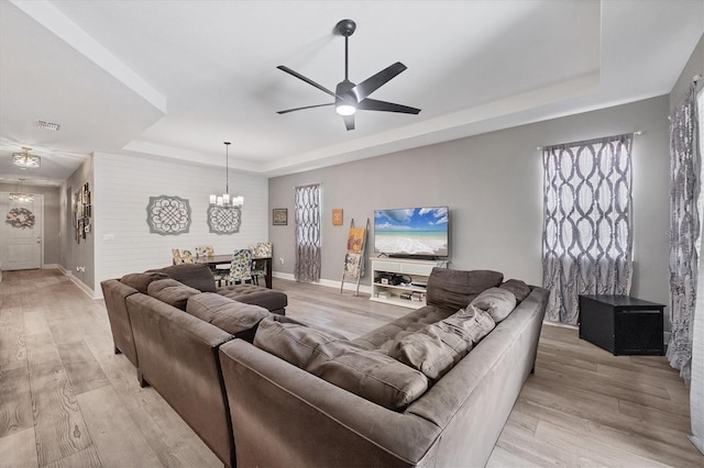 2034 Mesic Hammock Way, Venice, FL 34292 - living room with a tray ceiling, a chandelier, baseboards, and light wood finished floors