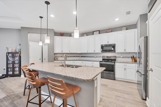 2034 Mesic Hammock Way, Venice, FL 34292 - kitchen featuring appliances with stainless steel finishes, a sink, light wood-style flooring, tasteful backsplash, and recessed lighting