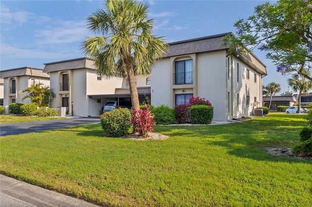 1728 S Lakeside Ct Unit 1720B, Venice, FL 34293 - view of building exterior with central AC unit, driveway, and a carport