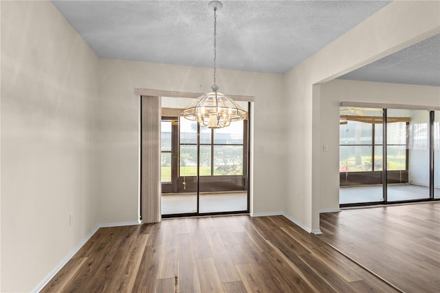 1728 S Lakeside Ct Unit 1720B, Venice, FL 34293 - unfurnished dining area featuring a chandelier, wood finished floors, baseboards, and a textured ceiling