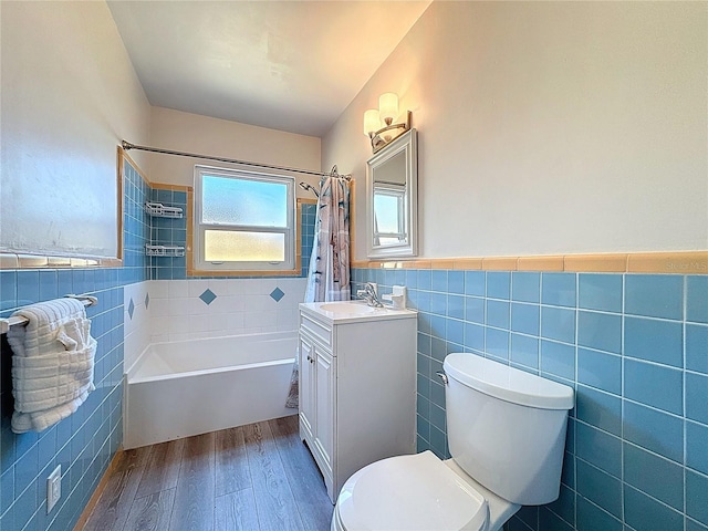 413 Valencia Rd, Venice, FL 34285 - full bath with tile walls, wood finished floors, vanity, shower / bath combo with shower curtain, and toilet