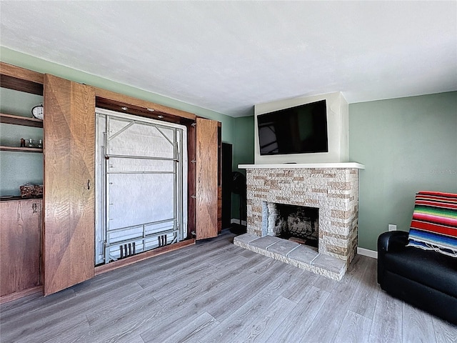 413 Valencia Rd, Venice, FL 34285 - living area featuring wood finished floors, a stone fireplace, and baseboards