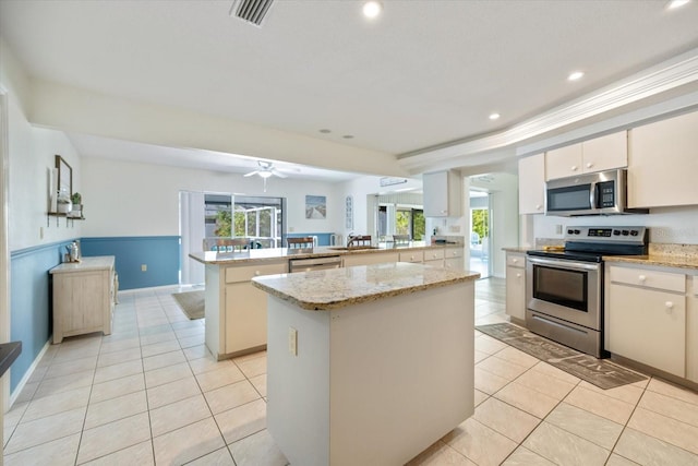 9277 Saint Catherine Ave, Englewood, FL 34224 - kitchen with stainless steel appliances, a peninsula, light tile patterned floors, healthy amount of natural light, and recessed lighting