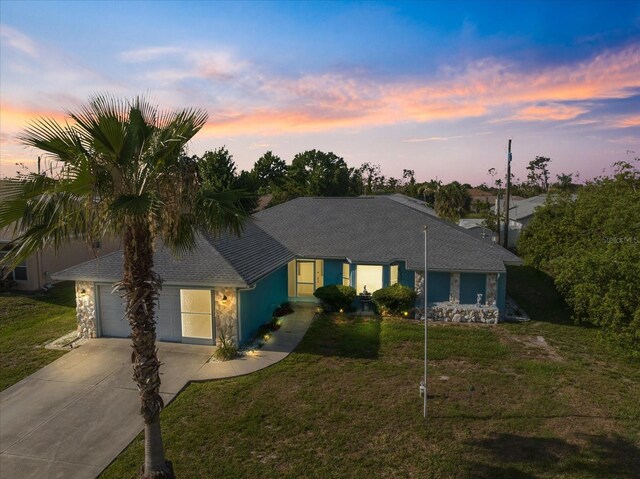 9277 Saint Catherine Ave, Englewood, FL 34224 - ranch-style home with concrete driveway, a garage, and a front lawn