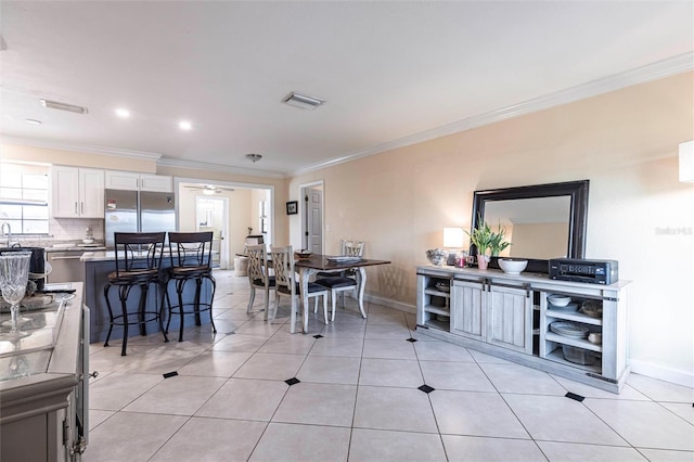 306 E Penn Rd, Lehigh Acres, FL 33936 - dining space with ornamental molding, baseboards, ceiling fan, and light tile patterned floors
