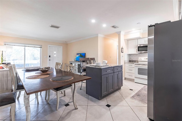 306 E Penn Rd, Lehigh Acres, FL 33936 - kitchen with appliances with stainless steel finishes, ornamental molding, decorative backsplash, white cabinetry, and gray cabinetry