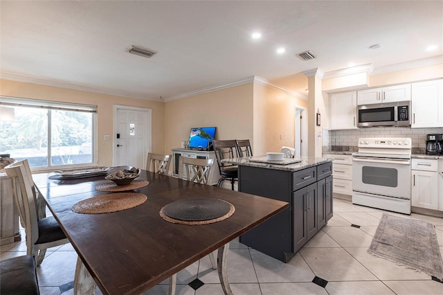 306 E Penn Rd, Lehigh Acres, FL 33936 - kitchen featuring electric range, stainless steel microwave, white cabinets, crown molding, and a kitchen island