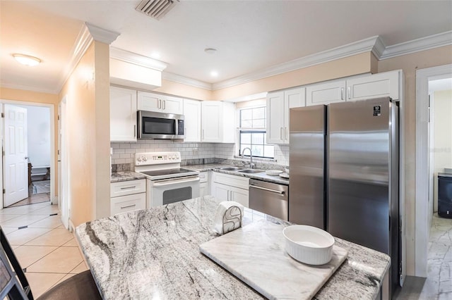306 E Penn Rd, Lehigh Acres, FL 33936 - kitchen featuring appliances with stainless steel finishes, a sink, white cabinetry, decorative backsplash, and light stone counters