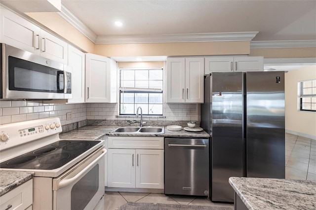 306 E Penn Rd, Lehigh Acres, FL 33936 - kitchen featuring appliances with stainless steel finishes, a sink, ornamental molding, tasteful backsplash, and white cabinetry