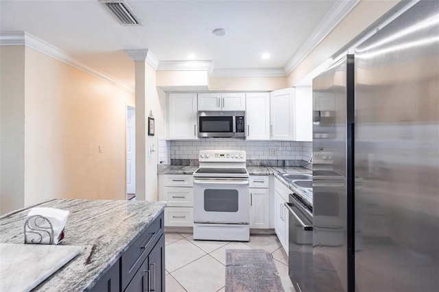 306 E Penn Rd, Lehigh Acres, FL 33936 - kitchen featuring appliances with stainless steel finishes, crown molding, white cabinetry, decorative backsplash, and light stone countertops