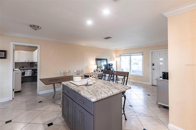 306 E Penn Rd, Lehigh Acres, FL 33936 - kitchen featuring a center island, ornamental molding, a kitchen breakfast bar, baseboards, and light tile patterned floors