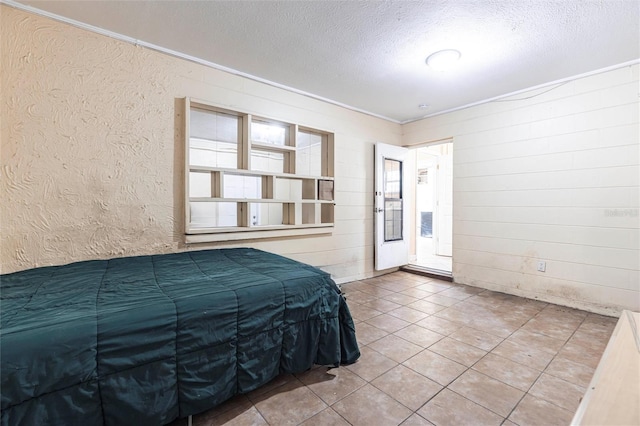 306 E Penn Rd, Lehigh Acres, FL 33936 - bedroom with a textured ceiling, tile patterned floors, and wood walls