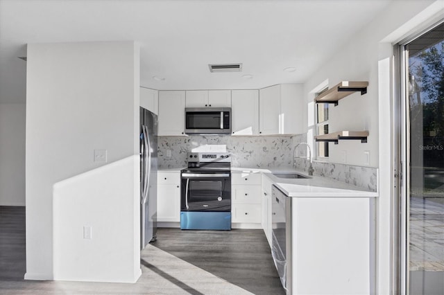 1032 Elaine St, Venice, FL 34285 - kitchen with appliances with stainless steel finishes, a sink, open shelves, dark wood-style flooring, and white cabinetry
