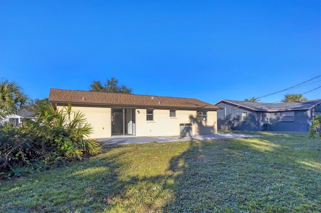 1032 Elaine St, Venice, FL 34285 - rear view of house with stucco siding, a lawn, and a patio