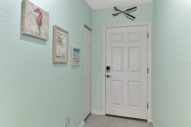 8409 Placida Rd Unit 206, Placida, FL 33946 - doorway to outside featuring light tile patterned floors, baseboards, and a textured wall