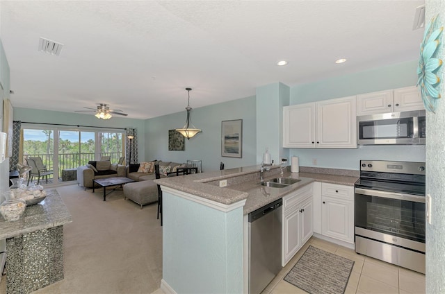 8409 Placida Rd Unit 206, Placida, FL 33946 - kitchen featuring appliances with stainless steel finishes, a sink, white cabinetry, a peninsula, and ceiling fan