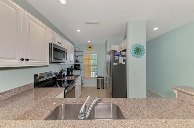 8409 Placida Rd Unit 206, Placida, FL 33946 - kitchen with stainless steel appliances, a sink, white cabinets, recessed lighting, and light stone countertops