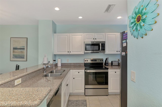 8409 Placida Rd Unit 206, Placida, FL 33946 - kitchen with stainless steel appliances, a sink, light tile patterned floors, white cabinets, and recessed lighting