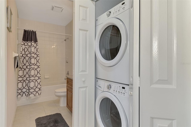8409 Placida Rd Unit 206, Placida, FL 33946 - laundry room with estacked washer and dryer, light tile patterned floors, and baseboards