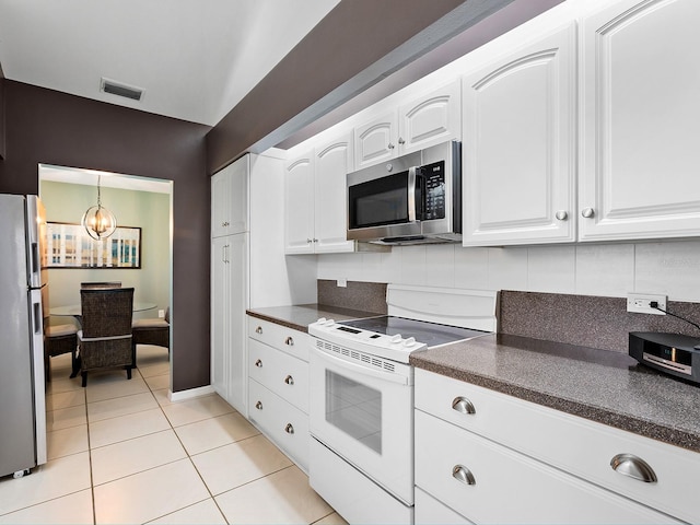 114 Southampton Pl N Unit 237, Venice, FL 34293 - kitchen featuring stainless steel appliances, dark countertops, white cabinets, a chandelier, and light tile patterned flooring