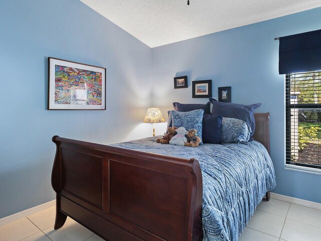 114 Southampton Pl N Unit 237, Venice, FL 34293 - bedroom with baseboards, light tile patterned floors, and a textured ceiling
