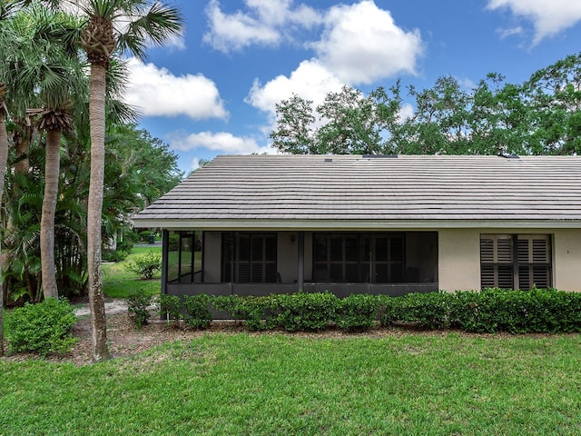 114 Southampton Pl N Unit 237, Venice, FL 34293 - back of property featuring a yard, a sunroom, stucco siding, and a tile roof