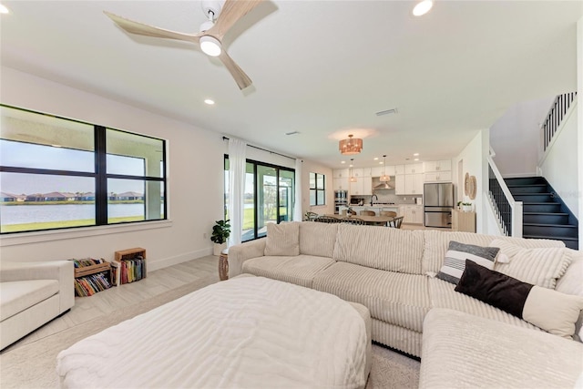 12816 Morning Mist Pl, Venice, FL 34293 - living room featuring recessed lighting, stairs, a ceiling fan, baseboards, and a water view
