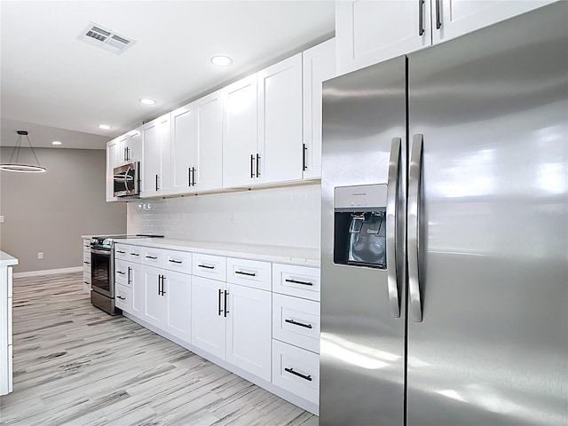 7140 Teaberry St, Englewood, FL 34224 - kitchen with appliances with stainless steel finishes, light countertops, white cabinetry, light wood finished floors, and recessed lighting